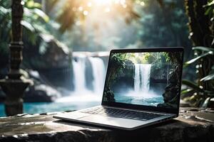AI generated Laptop with waterfall in the tropical jungle wallpaper on table on a mountain lake in the rocks with waterfall. Remote work on vacation and travel, home office, internet, tours, trekking. photo