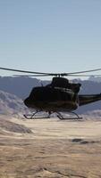 A helicopter flying over a desert landscape with mountains in the background video