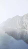 uma sereno montanha lago refletindo a em torno da picos video