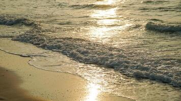 hermosa puesta de sol playa resumen textura antecedentes. cerca arriba suave ola lapeado el arenoso playa, verano antecedentes. hermosa mar olas con espuma de dorado color aislado. foto