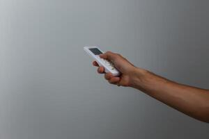 hand holding remote control on white background photo