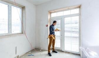 Worker in glazier's workshop, warehouse or storage handling glass photo