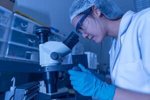 Asian scientist working in the lab,Researchers are research to find the results of the experiment,doctors are testing bloods to prevent and destroy new strains of the coronavirus through microscopy. photo