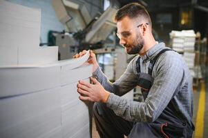 Man working in printing house with paper and paints photo