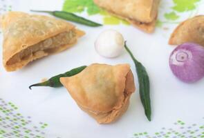 un samosa es un frito Pastelería desde sur Asia ese es lleno con sabroso ingredientes incluso guisantes, cerdo, pez, cebollas, o picante papas. además llamado shingara. foto