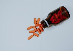 Pill bottle spilled in surface isolated on white background. Top view. photo