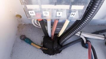 Three phase cables power input , neutral and grounding cable on the panel control. Terminal Block R-S-T-N for three phase Electrical system wiring. photo