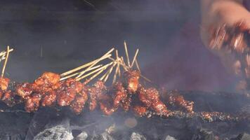 kip saté Aan vurig houtskool grillen door mensen in Indonesië video