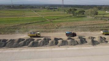 Aerial view of the construction of the highway. Dump truck is passing by the construction. video