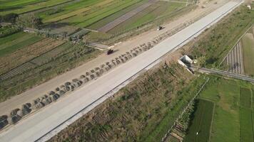 Aerial view of the construction of the highway. Dump truck is passing by the construction. video