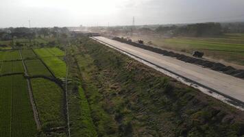 aereo Visualizza di il costruzione di il autostrada. cumulo di rifiuti camion è passaggio di il costruzione. video