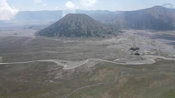 Aerial view of active volcano with crater in depth. Brown dirt around. clouds of smoke on volcano, Mount Bromo, Indonesia video