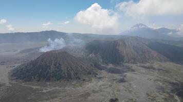 Aerial view of active volcano with crater in depth. Brown dirt around. clouds of smoke on volcano, Mount Bromo, Indonesia video