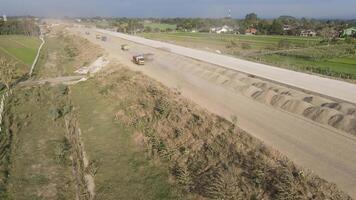 aéreo ver de el construcción de el carretera. tugurio camión es paso por el construcción. video