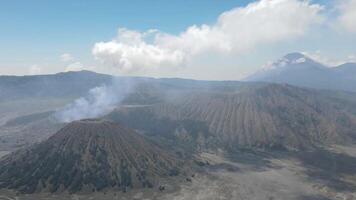 Timelapse of aerial view of active volcano with crater in depth. Brown dirt around. clouds of smoke on volcano, Mount Bromo, Indonesia video