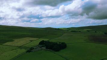 Rolling green hills under a cloudy sky, with patches of sunlight and shadows on the landscape. video