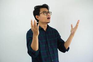 young Asian man looks up showing a regretful expression with his arms open isolated on white background photo