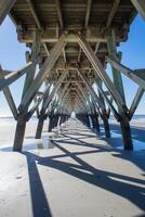 mirando fuera debajo un pescar muelle con oscuridad emitir desde pilotes foto