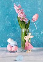 Pink Easter decorations decorative eggs, cute wooden bunny, jacinth flower in glass. Vertical format photo