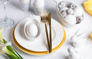 Festive elegant white with yellow Easter table setting Close up. photo