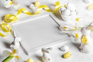 Easter creative card template in white yellow colors. Square frame, eggs, flowers, ribbon, bunnies. photo