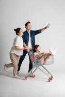 Image of Asian family pushing a supermarket cart while shopping, isolated on white background photo