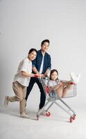 Image of Asian family pushing a supermarket cart while shopping, isolated on white background photo