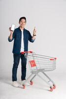 Happy smiling man pushing supermarket cart isolated on white background photo