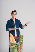 Happy smiling man pushing supermarket cart isolated on white background photo