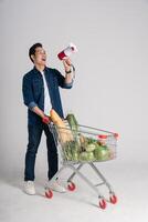 Happy smiling man pushing supermarket cart isolated on white background photo