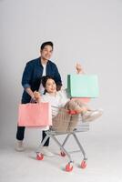 Happy smiling couple pushing supermarket cart isolated on white background photo