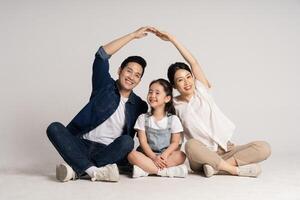 asiático familia retrato posando en blanco antecedentes foto