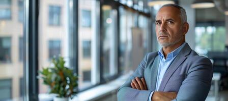 AI generated Confident senior businessman standing in white office with crossed arms and copy space photo