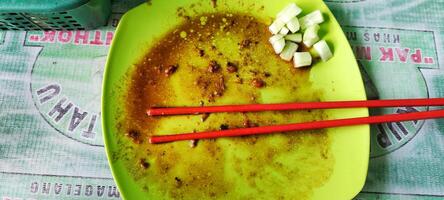 High angle view of a photo of the plate after eating, you can see several dirty tissue sheets and a pair of eating used chopsticks.