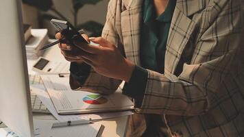 Asian businesswoman in formal suit in office happy and cheerful during using smartphone and working video