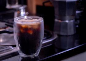 fresh espresso into a glass with ice cubes. Fresh ice coffee, espresso, with thick, soft crema foam to mix with water to make an Americano. Brew coffee from Arabica and Robusta beans. photo