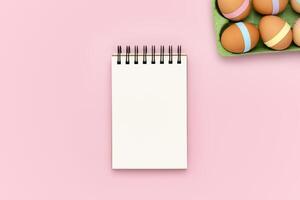 Blank notebook on pink background with egg carton photo