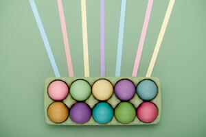 Green carton of painted eggs with leading lines. Geometric Easter background photo