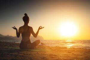 yoga mujer meditando a sereno puesta de sol o amanecer en el playa. el niña relaja en el loto posición. dedos doblada en mudras. foto