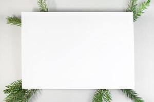Christmas composition. Blank card, Christmas tree branches on white background, flat lay. Winter background top view, copy space photo