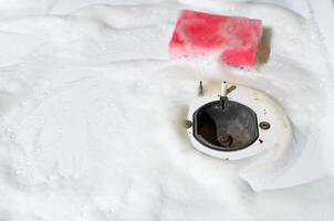 Sponge with foam lying on surface of gas stove, copy space. Hygienic cleaning kitchen photo