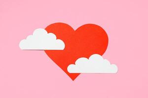 Valentine's Day concept. Red heart in the clouds on a pastel pink background. Greeting card design. Flat lay, top view, copy space photo