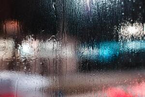 Abstract background of night city blurred. Glass surface after rain photo