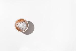 Powdered muffin. Minimalism, white table background. Flat lay, top view, copy space. photo