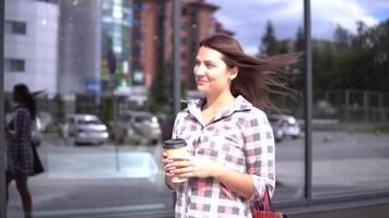 Beautiful young girl goes after shopping with bags in her arms drinking coffee. 4K video