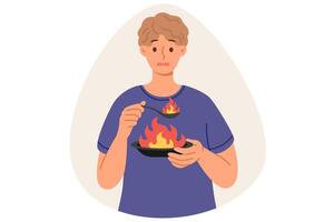 hombre come muy picante alimento, causando ardiente sensación en boca debido a sobreabundancia de pimienta, participación plato y cuchara con fuego. chico come picante plato con especias, hace insatisfecho mueca vector