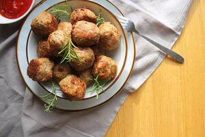 Roasted meatballs , delicious meat cutlets on wooden table . Top view photo