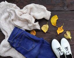 otoño hembra atuendo. conjunto de ropa, Zapatos y accesorios en de madera antecedentes foto