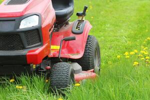 Mowing or cutting the long grass with a lawn mower . Gardening concept background photo