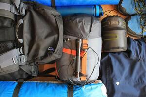 Flat lay composition with camping equipment on wooden background photo